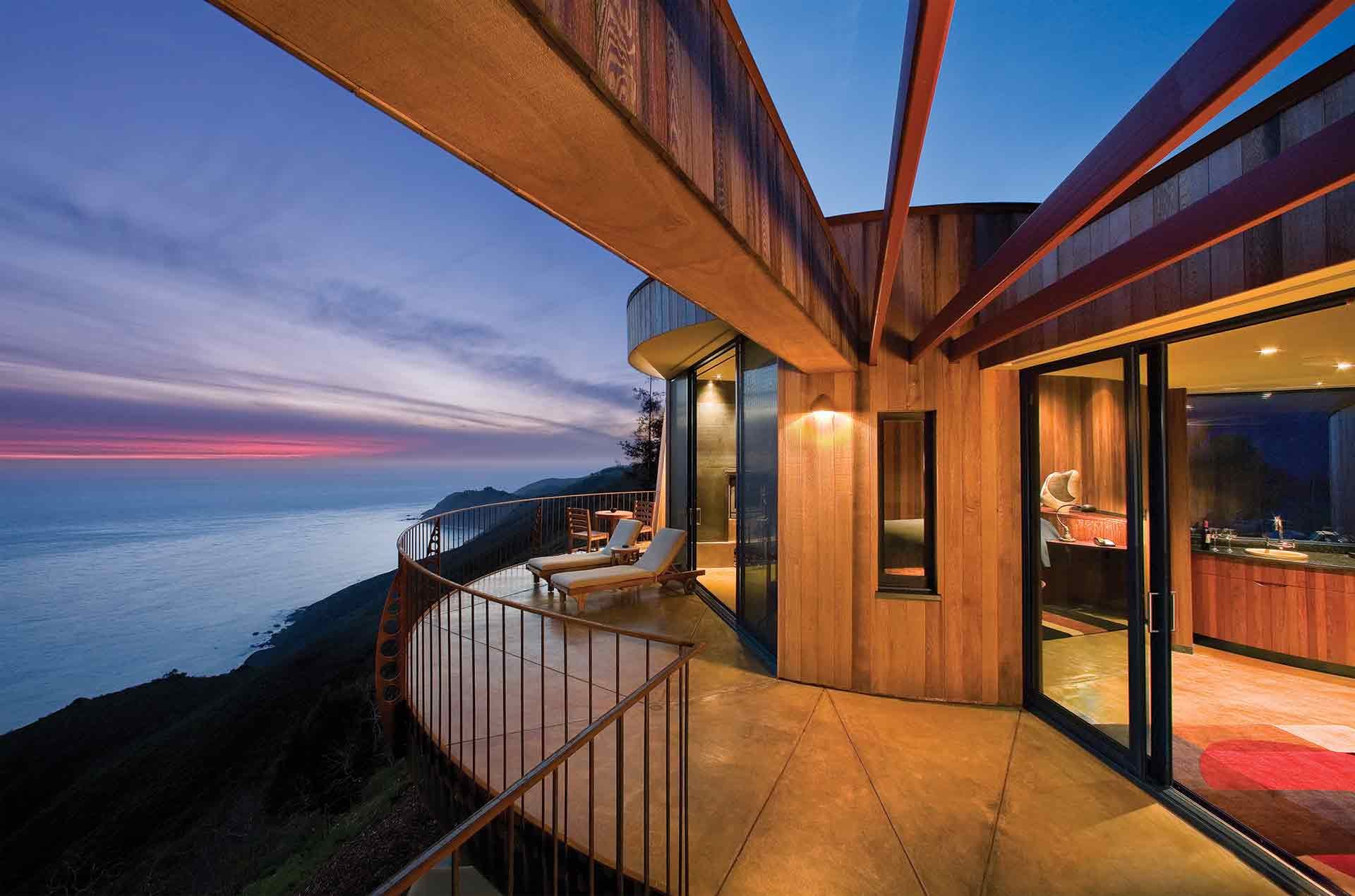 A cliff-edge suite balcony at dusk